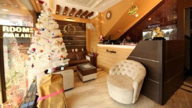 A hotel lobby with a Christmas tree, a reception desk, and a seating area. - Le Emerald Residency (Chennai)