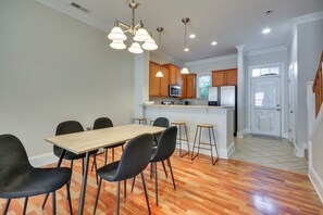 Una cocina moderna con armarios de madera, un microondas integrado y un refrigerador de acero inoxidable.