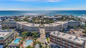 Un hotel con piscina, varias construcciones y vista al océano.