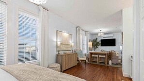 Un dormitorio con una cama grande, un aparador de madera, un escritorio y un televisor.