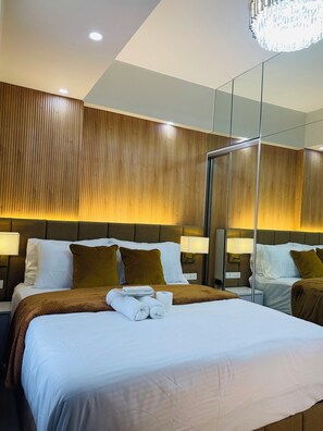 Relax in a stylish room with a large bed, nightstand, and mirror.