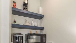 Cocina compacta equipada con microondas, tostadora y refrigerador.