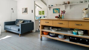 A modern living room with a blue sofa, wooden cabinets, and a coffee machine. - "Krister" - 900m from the sea by Interhome (Hasle)