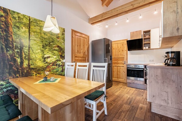 Une cuisine moderne avec des meubles en bois, un grand îlot central et un coin repas avec des chaises.