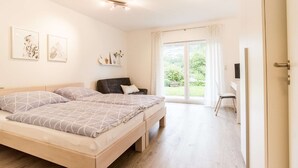 Une chambre à coucher avec un lit, un bureau, une chaise et une fenêtre avec des rideaux.