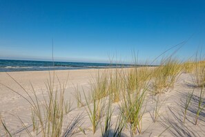 A beach with sand and grass. - Holiday Home 'Ostsee' with Private Terrace, Private Garden and Wi-Fi (Pruchten)