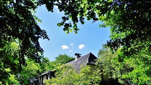 A traditional house surrounded by lush greenery and trees. - Holiday Apartment Mulleby with Shared Garden and Wi-Fi (Süderhackstedt)