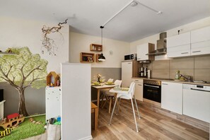 A modern kitchen with white cabinets, a microwave, and a dishwasher. - Arzgebirg Apartment with Whirlpool, Private Terrace & Treehouse for Children (Grünhainichen)