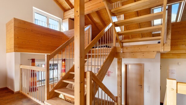 Un intérieur en bois à plusieurs niveaux, comprenant un escalier, une porte et une fenêtre.