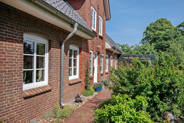 A row of brick houses with white windows and a brick pathway.