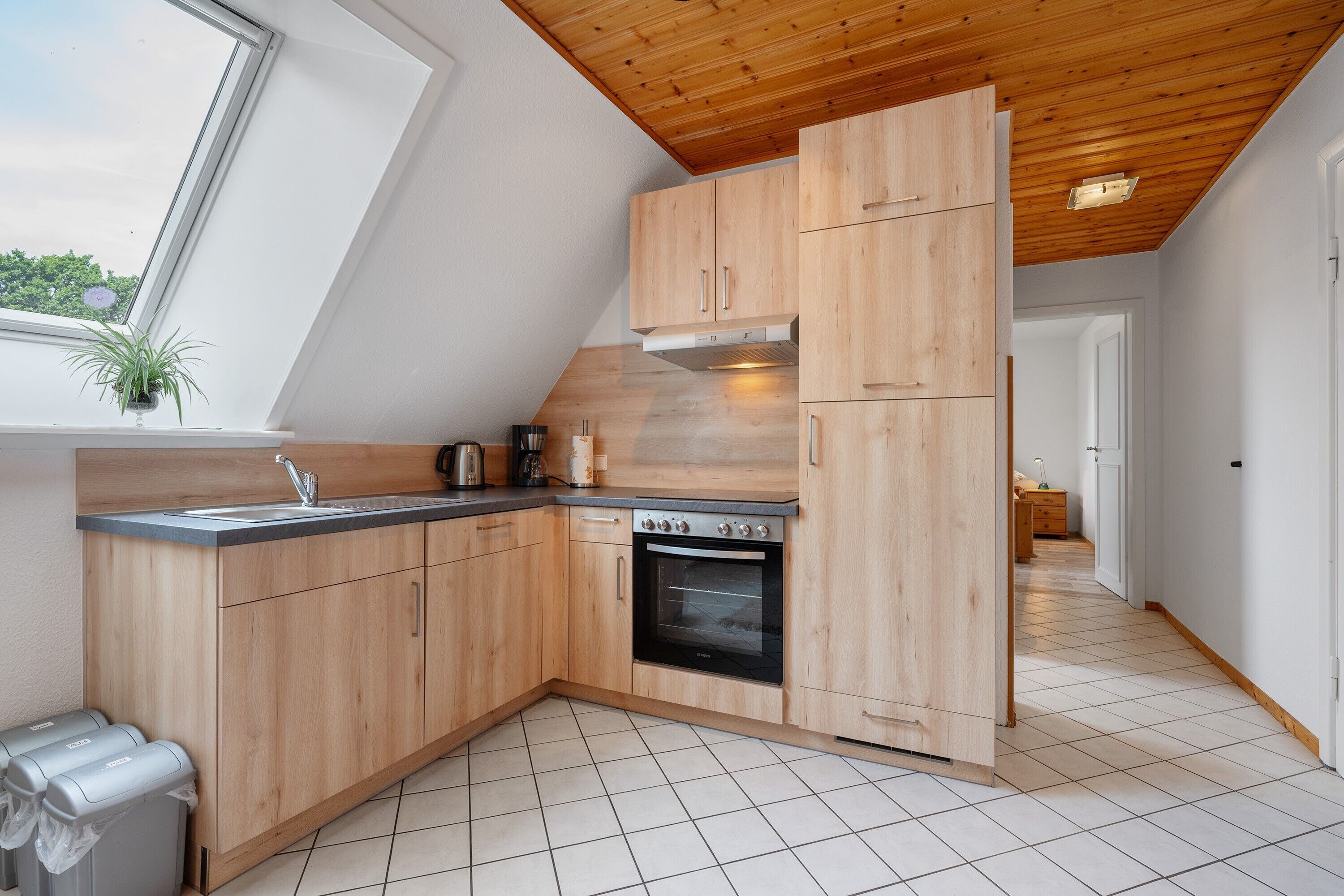 A kitchen with wooden cabinets, a sink, and an oven.