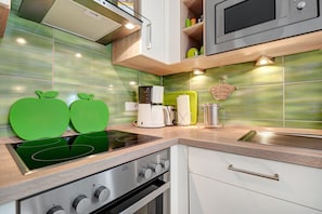 Een moderne keuken met een inbouwfornuis, magnetron en oven.