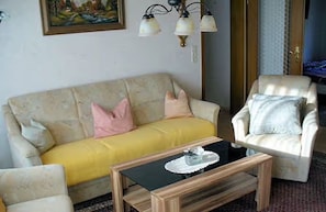 Ein Wohnzimmer mit Sofa, Sessel und Couchtisch.