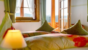 Una camera da letto con un letto, cuscini, una lampada e una finestra con tende.