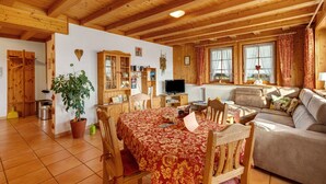 Un interno in legno con un tavolo da pranzo, sedie, un divano e una televisione.
