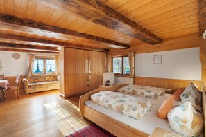 A wooden cabin with a bed, a sofa, and a dining area.