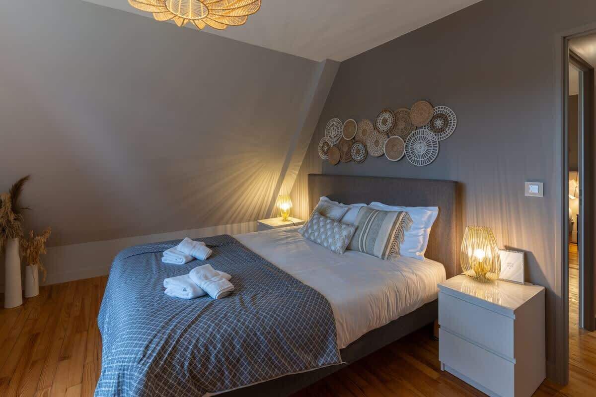 A bedroom with a bed, bedside tables, and wall decor.