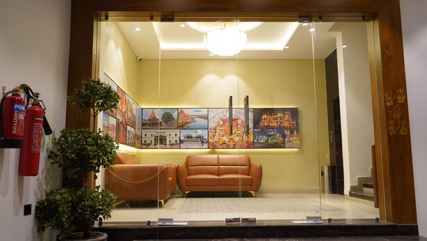 Un espace d’accueil avec un canapé, des plantes en pot et des œuvres d’art encadrées accrochées au mur.