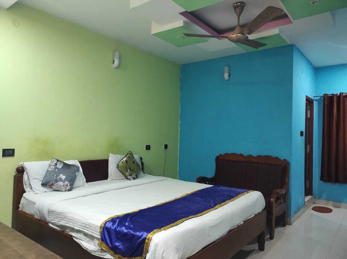Un dormitorio con cama, ventilador de techo y ventana con cortinas.