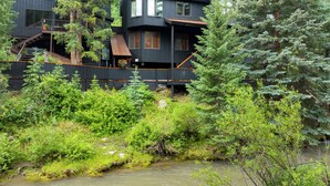A modern multi-story building with a wooden deck and stairs leading to the entrance. - Manitou River House 113 by AvantStay | A+ Location (Telluride)
