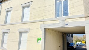 A building with a garage entrance, a number '22' sign, and a green 'Gîte' sign. - Véro's Lodges. Duplex 5 minutes from Verdun, private parking, garage for two-wheeled vehicles, air conditioning (Thierville-sur-Meuse)