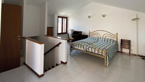 Een slaapkamer met een bed, een bureau en een stoel.