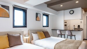 A hotel room with two beds, a kitchenette, and a dining area. - SeRENO Shinmachi 801 (Osaka)