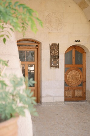 Uma porta arqueada com madeira e uma placa decorativa acima.