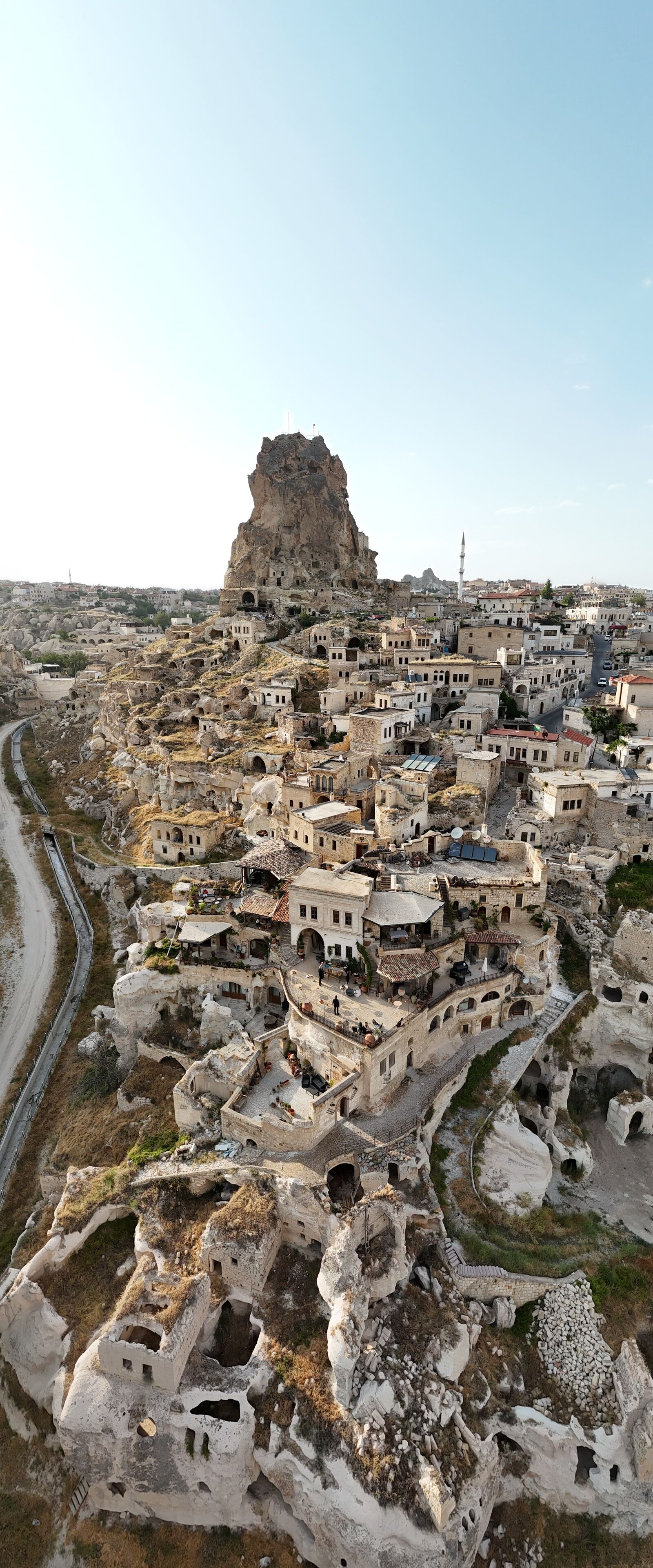 A historic town with traditional architecture, narrow streets, and a prominent rocky hill.