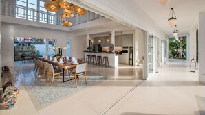 A spacious, modern kitchen with a central island, large windows, and a bright, airy atmosphere.