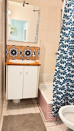 A bathroom with a wooden vanity, a mirror, a toilet, and a shower curtain. - Peaceful Studio 35m² + Private Sunny Courtyard | Prime Location in Marseille 6th (Marseille)