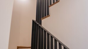 Eine Treppe mit Holzboden und schwarzen Geländern.