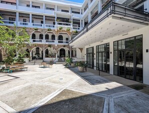 Une cour dotée d’une façade en pierre, de nombreux balcons et d’un espace aménagé pour s’asseoir à l’extérieur.