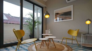 A room with a large window, a round table with chairs, a potted plant, and a framed picture on the wall. - w* | Comfortable Loft in Santa Ana (Panamá)