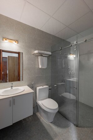 A modern bathroom with a glass-enclosed shower, a white sink, and a toilet. - Moon Valley Villas Da Lat (Xuan Huong - Da Lat)
