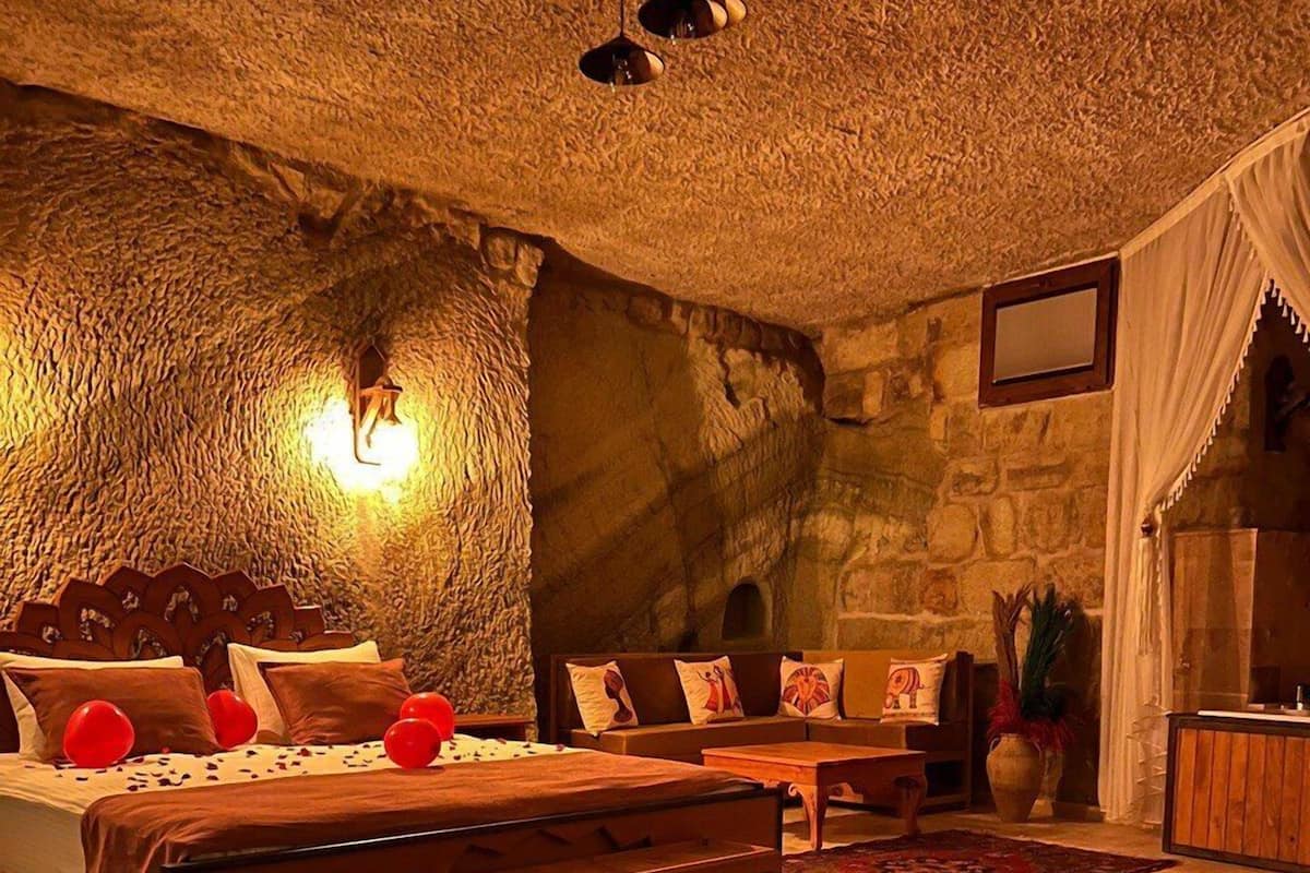 Un dormitorio acogedor y rústico con una pared de piedra, una cama de madera y una alfombra estampada.