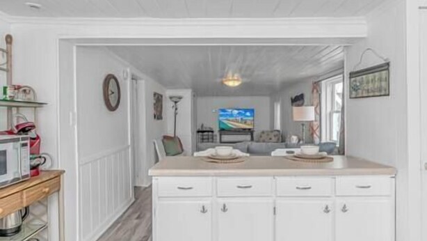 A kitchen with white cabinets, a microwave, and a wooden countertop. - 3 Blocks to Beach + FREE Golf Cart | Sleeps 10 (North Myrtle Beach)