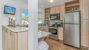 A modern kitchen with light wood cabinets, stainless steel appliances, and a marble countertop. - 3 Blocks to Beach + FREE Golf Cart | Sleeps 10 (North Myrtle Beach)