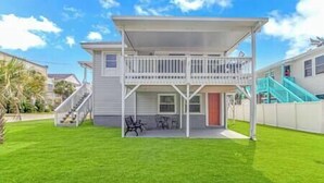 A two-story house with a covered patio, a staircase, and a fenced backyard. - 3 Blocks to Beach + FREE Golf Cart | Sleeps 10 (North Myrtle Beach)