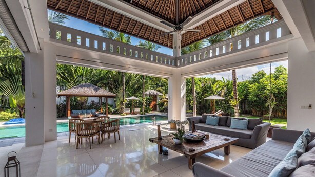 Amplo espaço interno com piscina, área de estar e ventilador de teto.