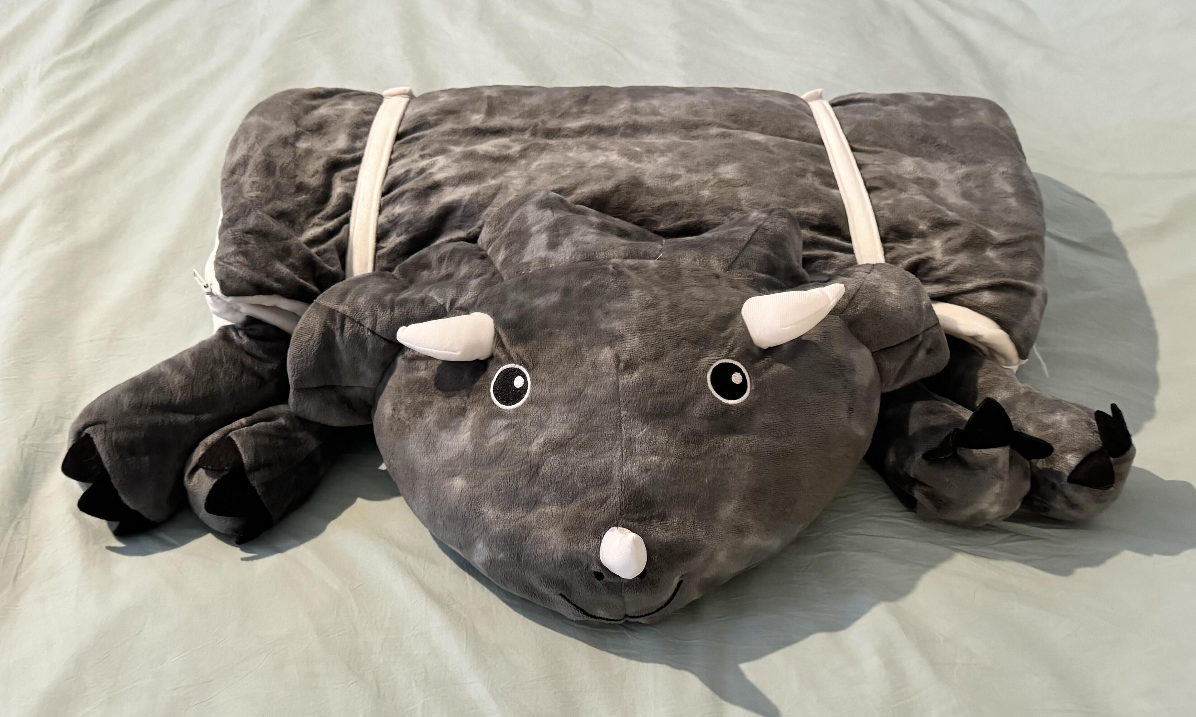 Un peluche con forma de toro descansando sobre una cama.