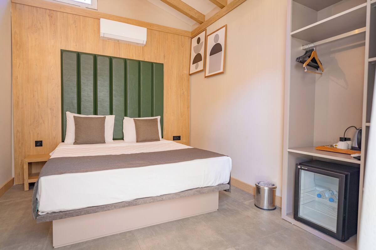 Un dormitorio con una cama, un refrigerador pequeño y un armario.