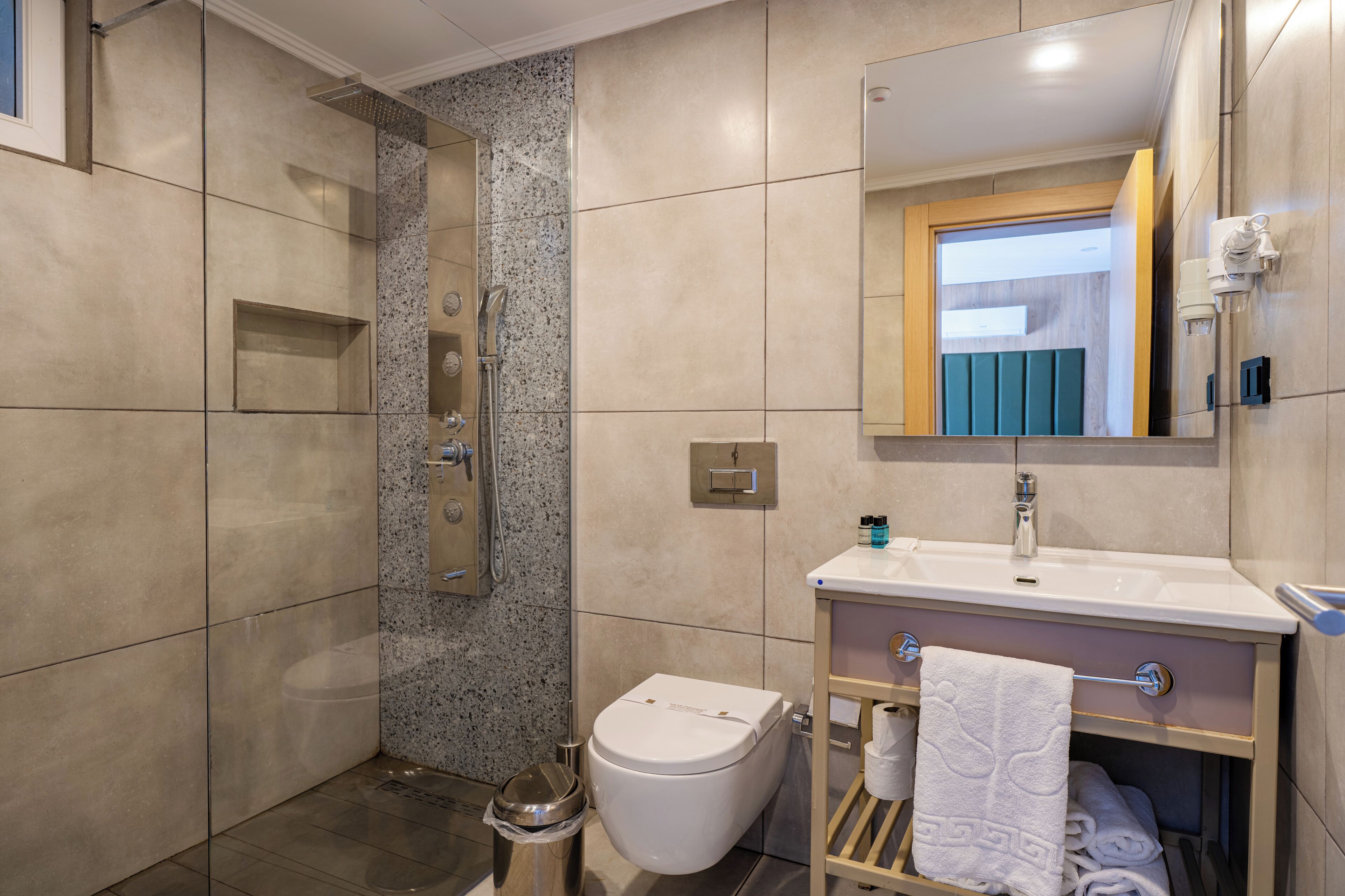 A modern bathroom with a shower, toilet, and sink.