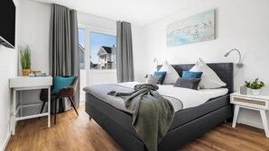 Ein modernes Schlafzimmer mit einem großen Bett, einem Schreibtisch und einem Stuhl.
