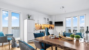 Ein modernes Apartment mit Essbereich, Küche und Balkon mit Blick.