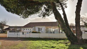 A house with a tiled roof, a white fence, and a grassy yard. - Côte Vendéenne Résidence le pin Parasol (Longeville-sur-Mer)