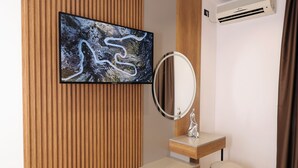 A modern bathroom with a wooden panel wall, a mounted mirror, a vanity, and a large artwork. - Emar Hotel (Tirana)
