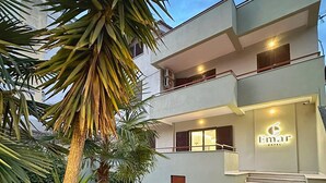 A modern hotel with a two-story structure, a well-maintained garden, and a visible entrance with steps. - Emar Hotel (Tirana)