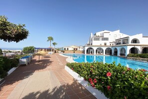 A resort with a swimming pool, white buildings, and a view of the sea. - Los Naranjos 15A (Nerja)