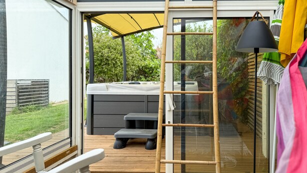 Una terraza con un jacuzzi, una escalera y una mesa.